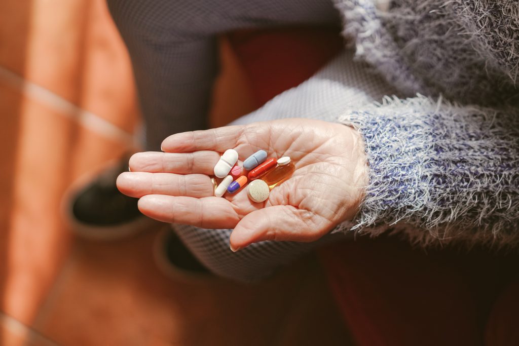 Lekovi u šaci starije osobe.