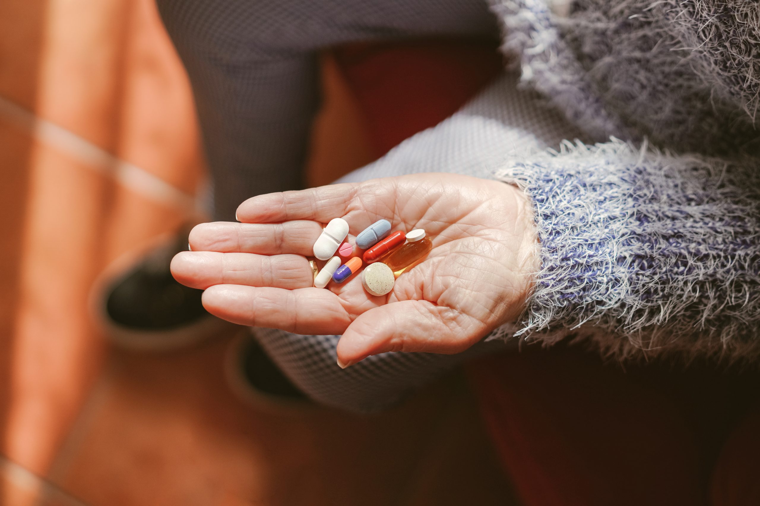 Lekovi u šaci starije osobe.